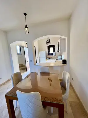 a dining room with a table and chairs and a kitchen at wast golf y 39-0-2 in Hurghada