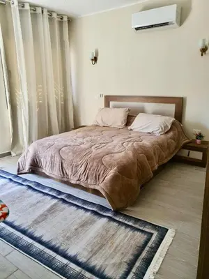 a bedroom with a large bed with a large window at Bali D-28 in Hurghada