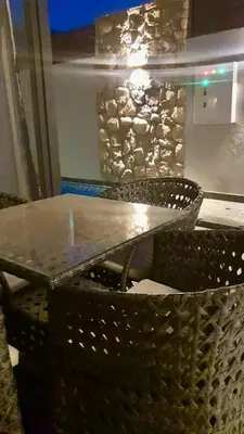 a table with two chairs and a stone wall at Bali D-28 in Hurghada
