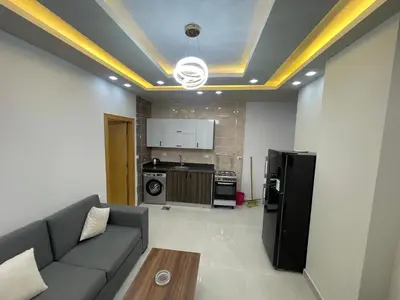 a living room with a couch and a refrigerator at Elamer building in Hurghada