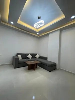 a living room with a black couch and a table at Elamer building in Hurghada