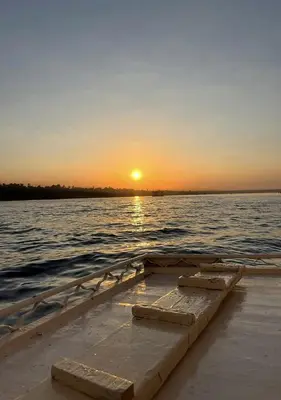 a boat sitting in the water at sunset at The Adventures of Aga Khan in Aswan