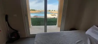 a bedroom with a bed and a window with a view at Joubal lagoon Elgouna 2BD in Hurghada