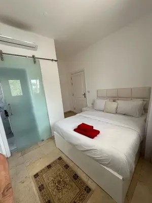a bedroom with a white bed with a red towel on it at white villa 4 bedroom elgouna heated pool in Hurghada