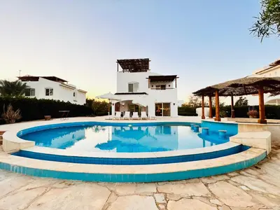 a swimming pool in front of a house at white villa 4 bedroom elgouna heated pool in Hurghada