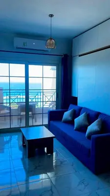 a blue living room with a couch and a table at Luxurious and Cozy Seafront Studio Near Gouna in Hurghada