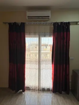 a large window with red curtains in a room at Tulip residence villa 1 in Hurghada