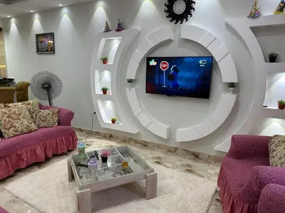 a living room with purple couches and a flat screen tv at Tulip residence villa 1 in Hurghada
