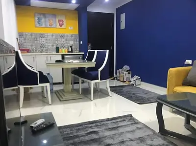 a living room with a table and chairs at Cozy Studio in modern resort in Hurghada