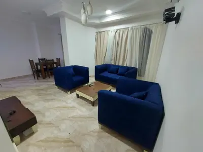 a living room with two blue chairs and a table at Golden key in Hurghada