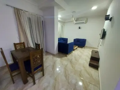 a living room with a table and blue chairs at Golden key in Hurghada