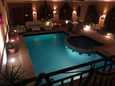 a large swimming pool in a living room with lights at Golden key in Hurghada