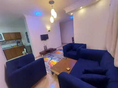 a living room with two blue chairs and a table at Golden key in Hurghada