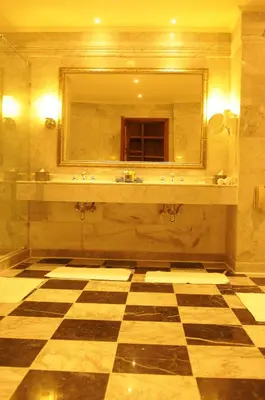 a bathroom with a large mirror and a checkered floor at HRG Best Hotel in Hurghada