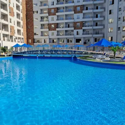 a large pool of blue water in front of buildings at Tiba Golden Beach Resort, Down Town in Hurghada