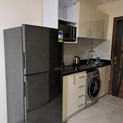 a kitchen with a refrigerator and a washing machine at Tiba Golden Beach Resort, Down Town in Hurghada