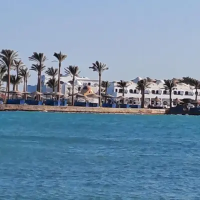 a view of a beach with palm trees and houses at Tiba Golden Beach Resort, Down Town in Hurghada