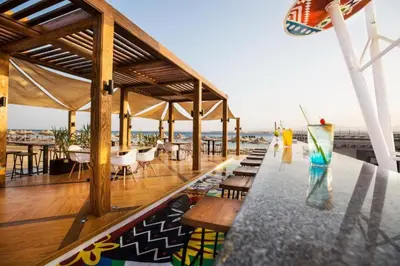 a restaurant with a table with chairs and a view of the ocean at Pyramisa Beach Resort Sahl Hasheesh in Hurghada