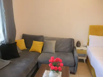 a living room with a gray couch and yellow pillows at new in Hurghada
