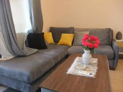 a couch with a table with a vase of flowers on it at new in Hurghada