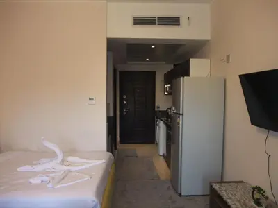 a small room with a refrigerator and a kitchen at new in Hurghada