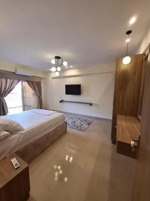a bedroom with a bed and a flat screen tv at Super luxury hotel apartment in Hurghada