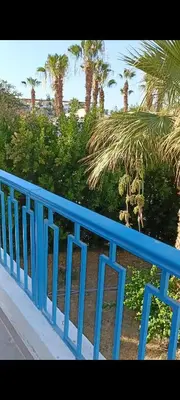 a blue railing with palm trees in the background at شاليه ميراج باى in Hurghada