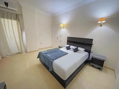 a bedroom with a large white bed and a window at Hadaba Studio in Hurghada