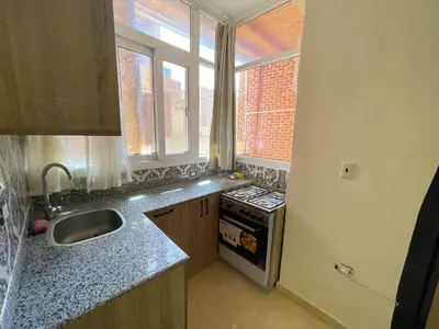 a kitchen with a sink and a stove and a window at Hadaba Studio in Hurghada