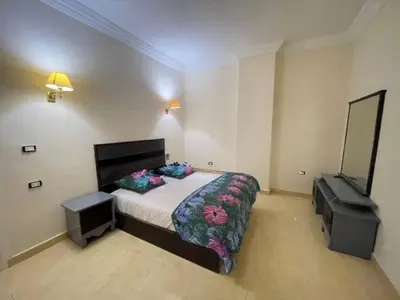 a bedroom with a large bed and a television at Hadaba Studio in Hurghada