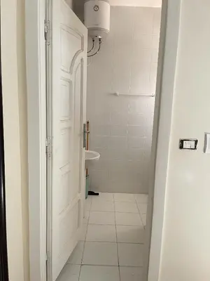 a bathroom with a white toilet and a sink at Hadaba Studio in Hurghada