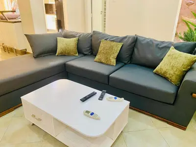 a living room with a blue couch and a coffee table at Magawish villa in the heart of the city in Hurghada