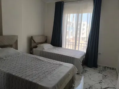 two beds in a room with a window at New 2bedroom apartment 7 min drive from Sheraton in Hurghada