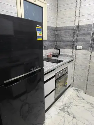 a kitchen with a stove and a black refrigerator at New 2bedroom apartment 7 min drive from Sheraton in Hurghada