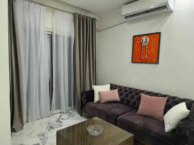 a living room with a brown couch and a table at New 2bedroom apartment 7 min drive from Sheraton in Hurghada