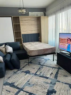 a bedroom with a bed and a couch and a television at Mackdi hights in Hurghada