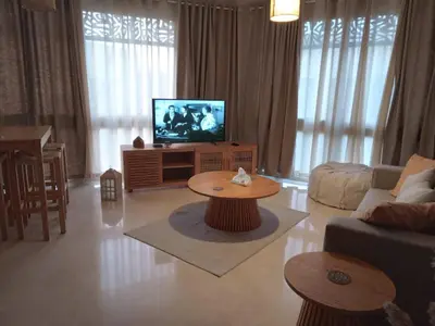 a living room with a couch and a tv at M8 free access to the BEACH and POOL in Hurghada
