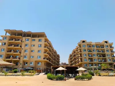 two large buildings with umbrellas in front of them at One Bedroom At Turtle Beach Compound With Private Beach in Hurghada