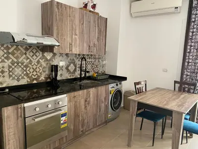 a kitchen with a table and a sink and a stove at Andreas Residence in Hurghada