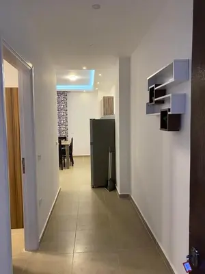 a hallway with a refrigerator and a table in a room at Andreas Residence in Hurghada