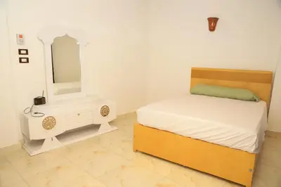 a bedroom with a bed and a dresser and a mirror at Karma house in Luxor