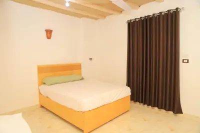 a bedroom with a bed and a black curtain at Karma house in Luxor