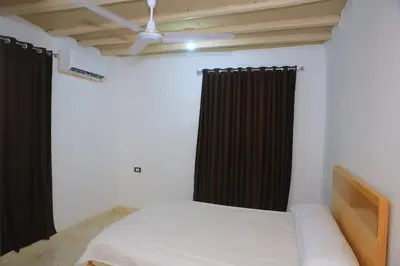 a bedroom with a bed and black curtains at Karma house in Luxor