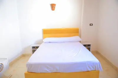 a bedroom with a bed with a wooden headboard at Karma house in Luxor