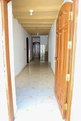 an empty hallway in a building with a wooden door at Karma house in Luxor