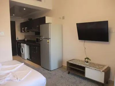 a room with a refrigerator and a tv on the wall at Victoria Aldau Heights Hurghada rent one bedroom Apartment in Hurghada