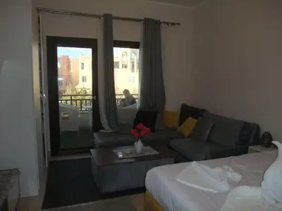 a living room with a couch and a table with flowers at Victoria Aldau Heights Hurghada rent one bedroom Apartment in Hurghada