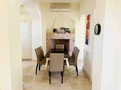 a dining room with a table and chairs and a fireplace at Private Villa with heated pool and lagoon in Hurghada