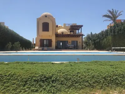 a house with a swimming pool in front of it at Villa, with heated Pool and Lagoon in Hurghada