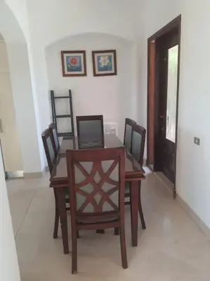 a dining room with a wooden table and chairs at Villa, with heated Pool and Lagoon in Hurghada